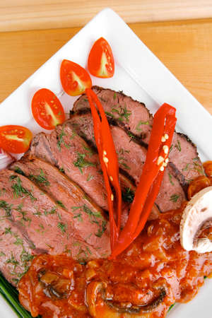 grilled beef slice on plate over wooden tableの写真素材