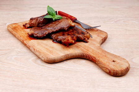 bbq beef meat fillet on wooden plate with cutleryの写真素材