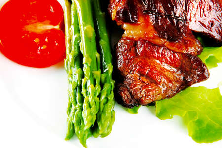 roasted beef meat served with asparagus on plateの写真素材