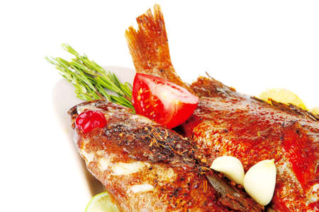 savory on plate: two fried fish served with tomatoes lemon and rosemary