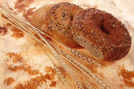 three different fresh bagels  over baking paper as backgroundの写真素材