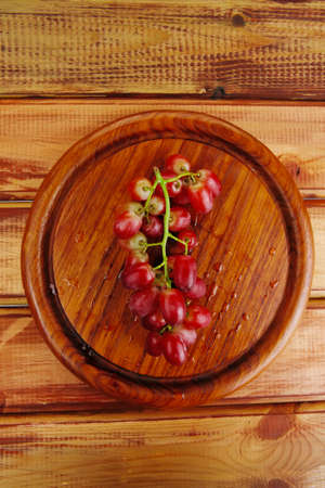 fresh raw red grape on wooden tableの写真素材