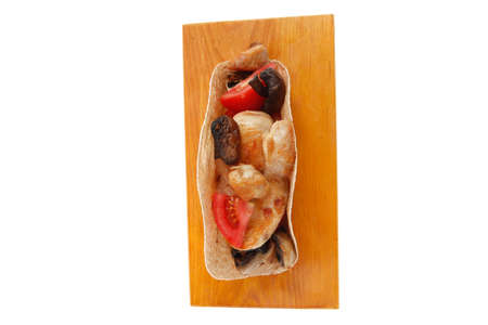 big mexican taco with tomatoes and mushroom on wood plate isolated over white backgroundの写真素材