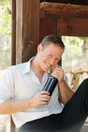 young happy white Caucasian man enjoy red wine in outdoorの写真素材
