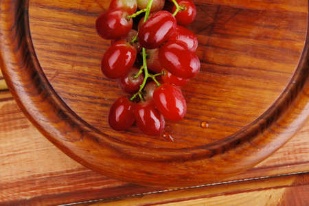 fresh raw red grape on wooden tableの写真素材