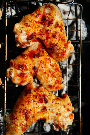 bbq grill meat - ready chicken wings on grid over charcoalの写真素材