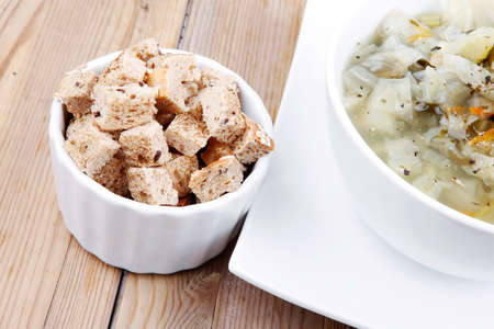 diet food : hot vegetable soup with bread  crackers in white bowl on  stand over wood tableの写真素材
