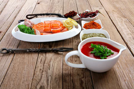 breakfast delicious portion of fresh roast salmon fillet with green chili sauce tomato soup dry spices over wooden table with black forged handmade cutlery - healthy food, diet cooking conceptの写真素材