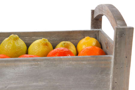 fresh raw lemon and mandarin packed in wooden box ready for transportation isolated over white backgroundの写真素材