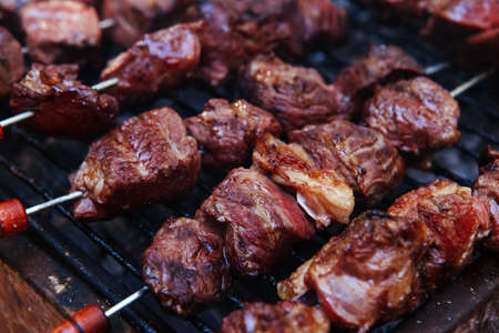fresh raw turkey fillet steak red meat brisket on skewers barbecue brazier grid full burned charcoalの写真素材