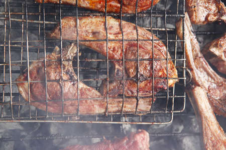 grilled roast meat lamb ribs on barbecue grid over charcoalの写真素材
