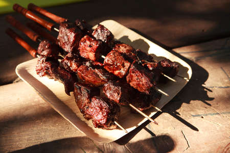 fresh raw beef fillet steak red meat brisket on skewers barbecue brazier grid full burned charcoal