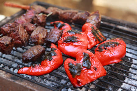 fresh raw beef fillet steak red meat brisket on skewers with grilled pepper barbecue brazier grid full burned charcoal selective focusの写真素材