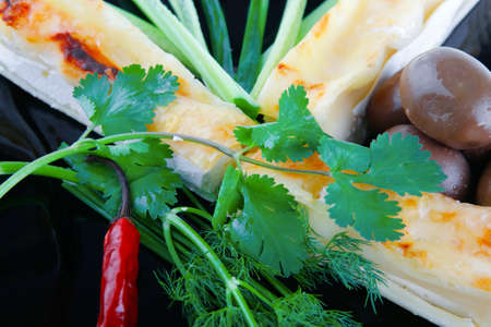 cheese cannelloni served with vegetables on black plateの写真素材