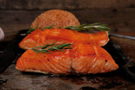 delicious portion of raw fresh salmon fillet with aromatic herbs and spices on vintage tray over wooden table - healthy food, diet cooking conceptの写真素材