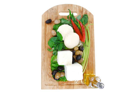 diet food : greek feta white cheese served on wooden plate with basil leaves red hot pepper , black and green olives , and olive oil isolated over white backgroundの写真素材