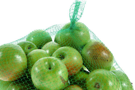 fresh green apples in green transport net ready to sell isolated on white backgroundの写真素材