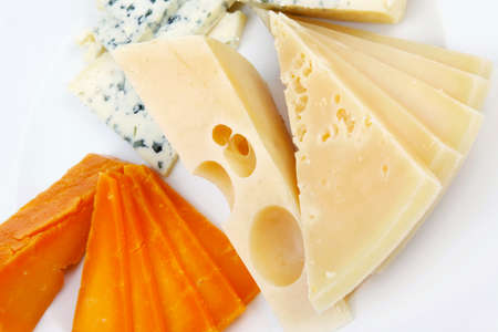 old blue stilton roquefort with orange cheddar and yellow parmesan and slices on plate with isolated...