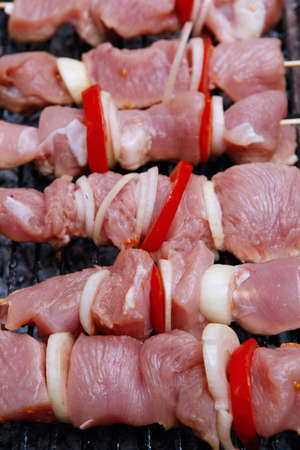 fresh raw turkey pork red meat fillet shish kebab on wooden skewers over vintage kind brazier full with ready charcoalの写真素材