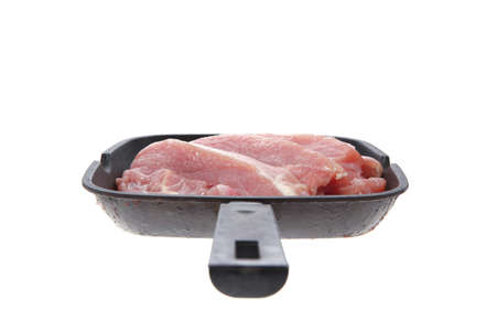 fresh raw turkey pieces on black pan isolated over white backgroundの写真素材