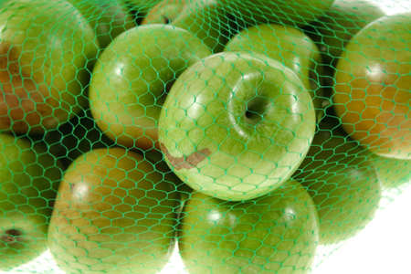 fresh green apples in green transport net ready to sell isolated on white backgroundの写真素材