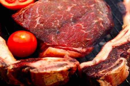 fresh raw beef meat fillet and asado ribs with vegetables prepared on deep charcoal bbq grill