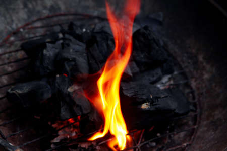 hot fire black wood charcoal in big round bbqの写真素材