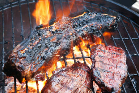 fresh red grilled beef meat fillet asado on deep round bbq grill over fireの写真素材