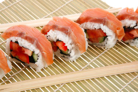 fresh japan onigiri inside out sashimi sushi on wooden bamboo mat with sticks isolated on white backgroundの写真素材