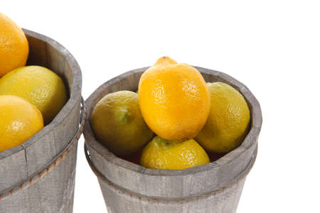 harvest of fresh raw lemon in wooden bucket isolated over white backgroundの写真素材