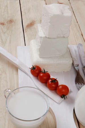 healthy dairy food fresh white greek goat sheep feta cheese on plate with milk in glass and full jug...