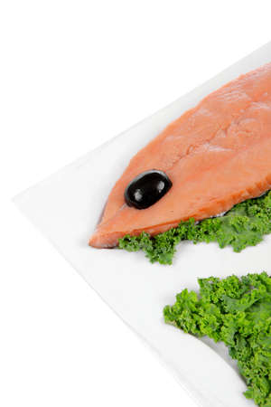healthy food - fresh raw red fish with kale lemon and black olives on plate isolated on white background space for textの写真素材