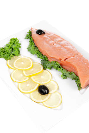 healthy food - fresh raw red fish with kale lemon and black olives on plate isolated on white background space for textの写真素材