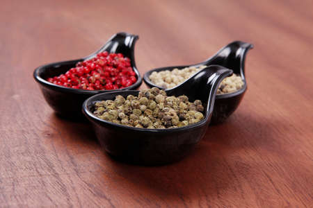 fresh dry peppercorn in small black bowl on wooden table ready to cook