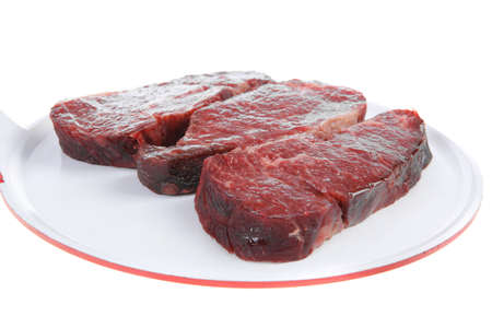three fresh raw marble beef meat sirloin porterhouse steak on big ceramic cooking pan isolated on white backgroundの写真素材