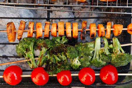 fresh raw vegetable kebab on bbq grid cooked over hot burned charcoalの写真素材
