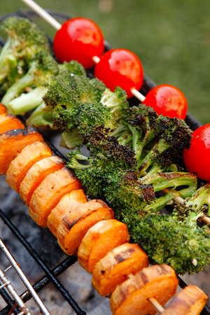 fresh raw vegetable kebab on bbq grid cooked over hot burned charcoalの写真素材