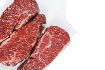 three fresh raw marble beef meat sirloin porterhouse steak on light wood cut board isolated on white backgroundの写真素材