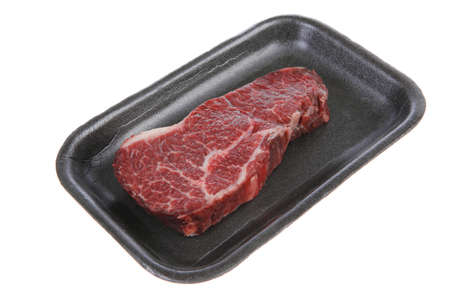 fresh raw marble beef meat steak on black plastic market tray isolated on white backgroundの写真素材