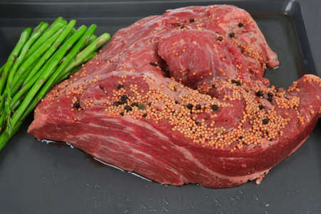 meat raw beef fillet chunk on black tray asparagus allspice isolated on white background empty space for textの写真素材