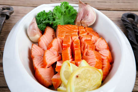 breakfast delicious portion of fresh roast salmon fillet with green chili sauce tomato soup dry spices over wooden table with black forged handmade cutlery - healthy food, diet cooking conceptの写真素材