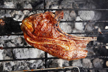 grilled roast meat lamb ribs on barbecue grid over charcoalの写真素材
