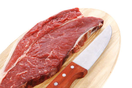 raw meat beefsteak fillet with knife on wood isolated over white backgroundの写真素材