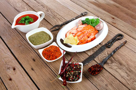 breakfast delicious portion of fresh roast salmon fillet with green chili sauce tomato soup dry spices over wooden table with black forged handmade cutlery - healthy food, diet cooking conceptの写真素材