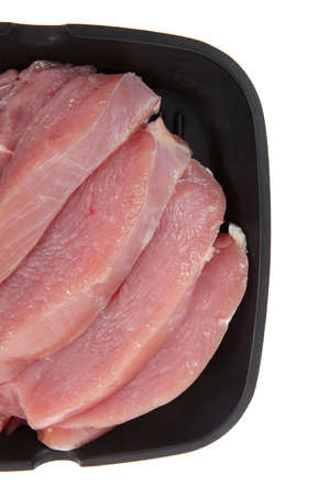 fresh raw turkey pieces on black pan isolated over white backgroundの写真素材