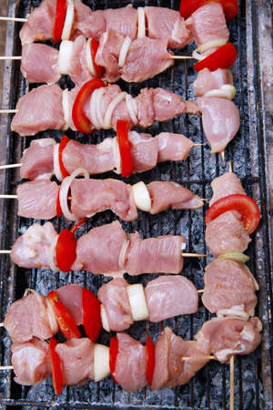 fresh raw turkey pork red meat fillet shish kebab on wooden skewers over vintage kind brazier full with ready charcoalの写真素材