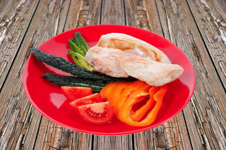 fresh roast turkey meat fillet steak served with vegetables on plate over wooden tableの写真素材