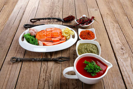 breakfast delicious portion of fresh roast salmon fillet with green chili sauce tomato soup dry spices over wooden table with black forged handmade cutlery - healthy food, diet cooking conceptの写真素材