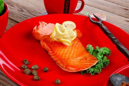 delicious portion of fresh roast salmon fillet on red plate with green salad kale tomato soup bbq sauce and black coffee over wooden table - healthy food, diet cooking concept kale tomato soup bbq sauce and black coffee over wooden table - healthy food, diet cooking conceptの写真素材