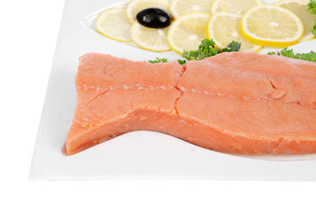 healthy food - fresh raw red fish with kale lemon and black olives on plate isolated on white background space for textの写真素材
